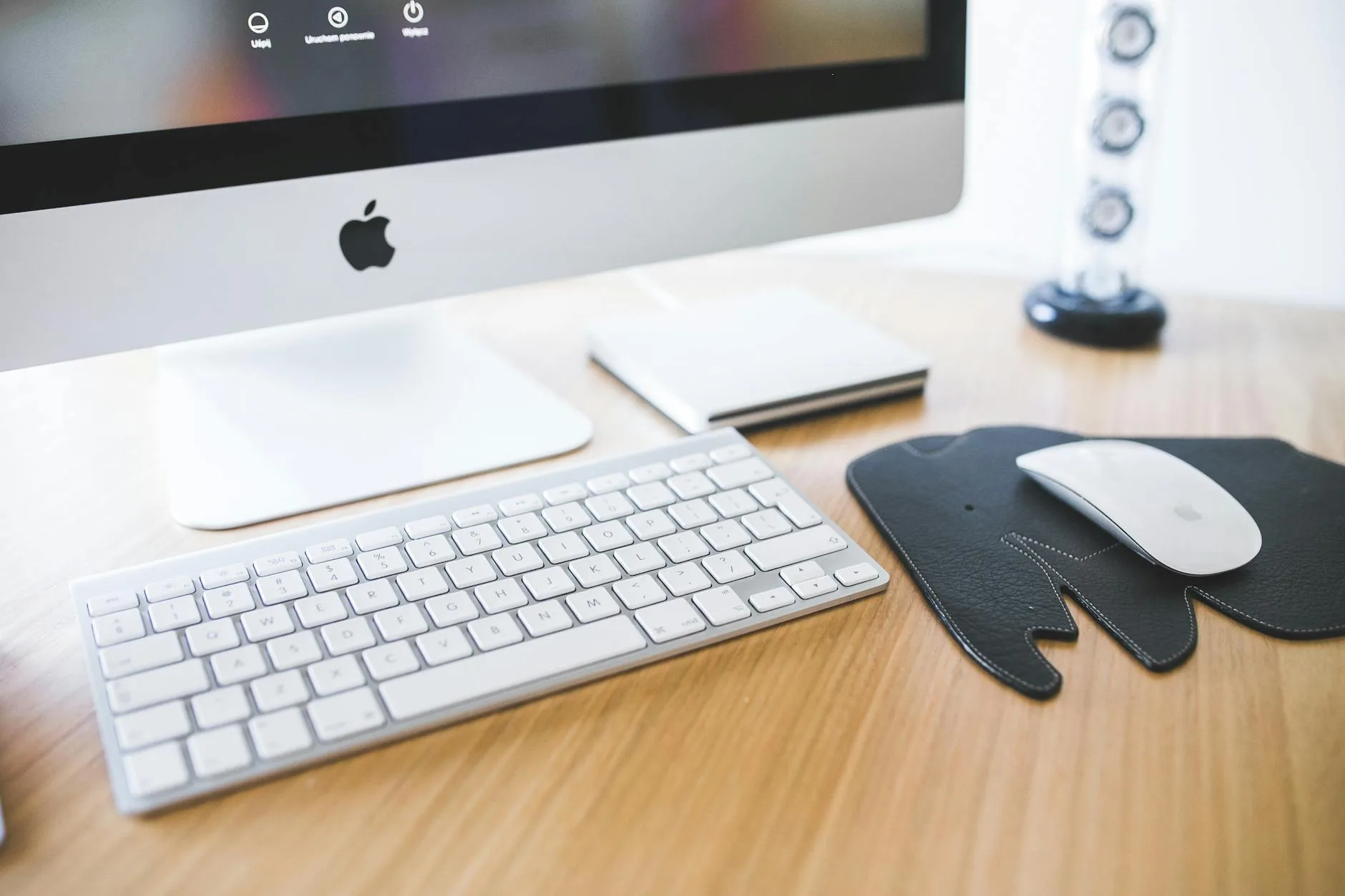 Ergonomiczne stanowisko z iMakiem na drewnianym biurku do pracy zdalnej