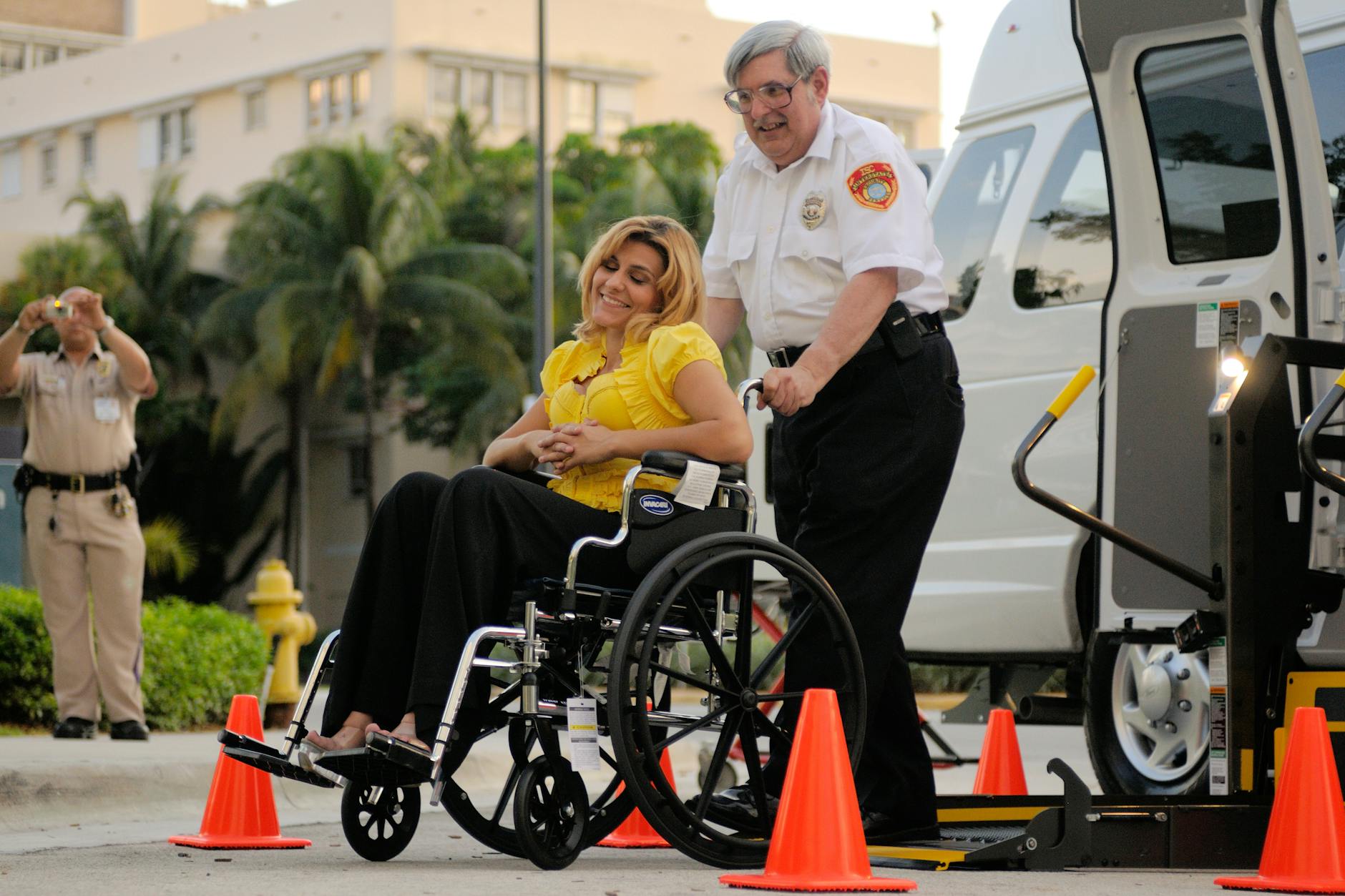 Kobieta na wózku wjeżdża na platformę podnośnika do pojazdu