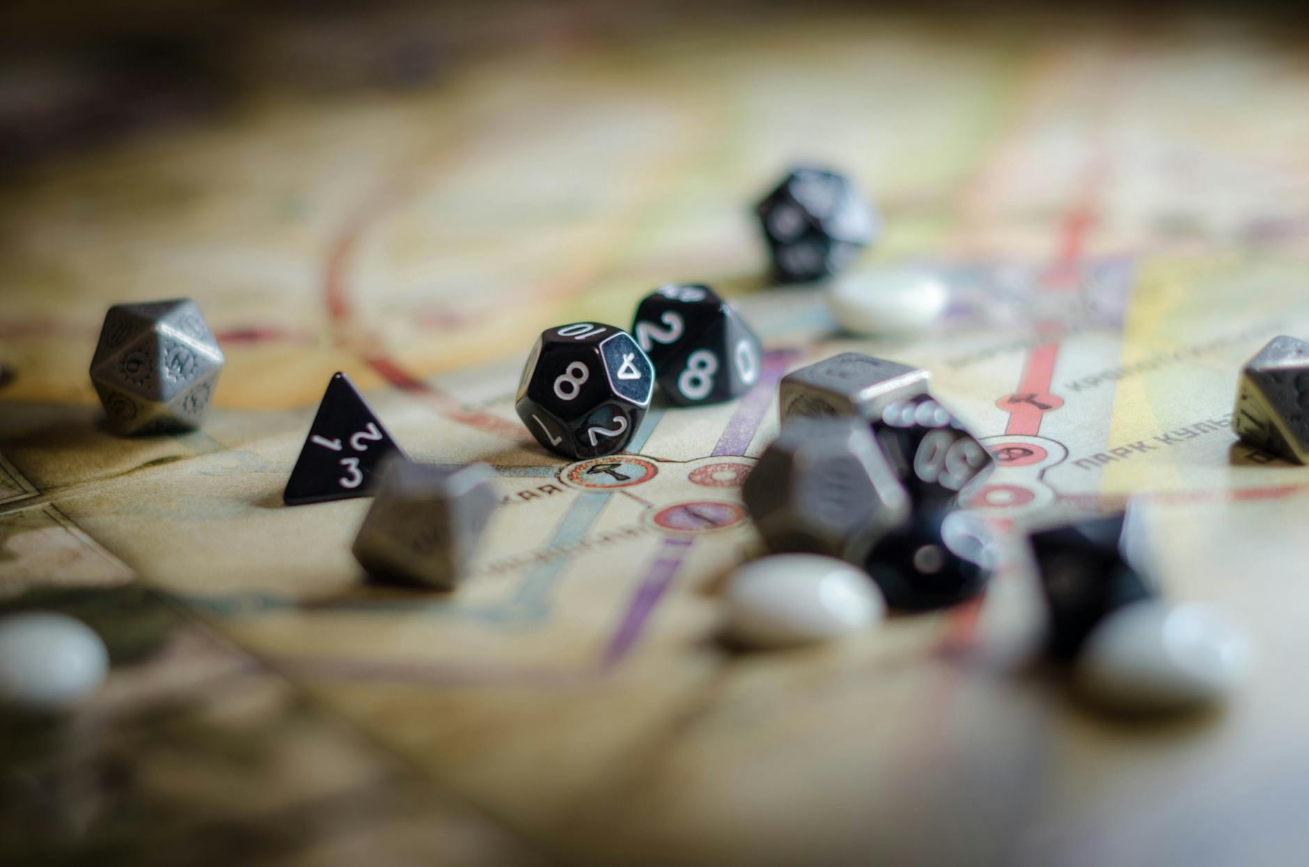 Czarno-białe kostki RPG rozsypane na mapie przygodowej