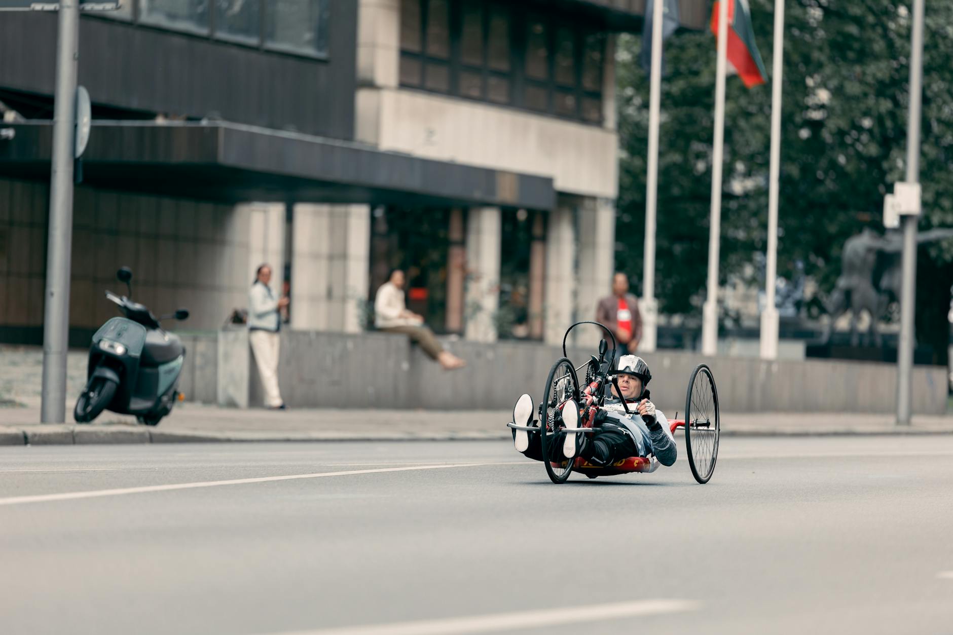 Mężczyzna jadący handbike’iem po miejskiej ulicy