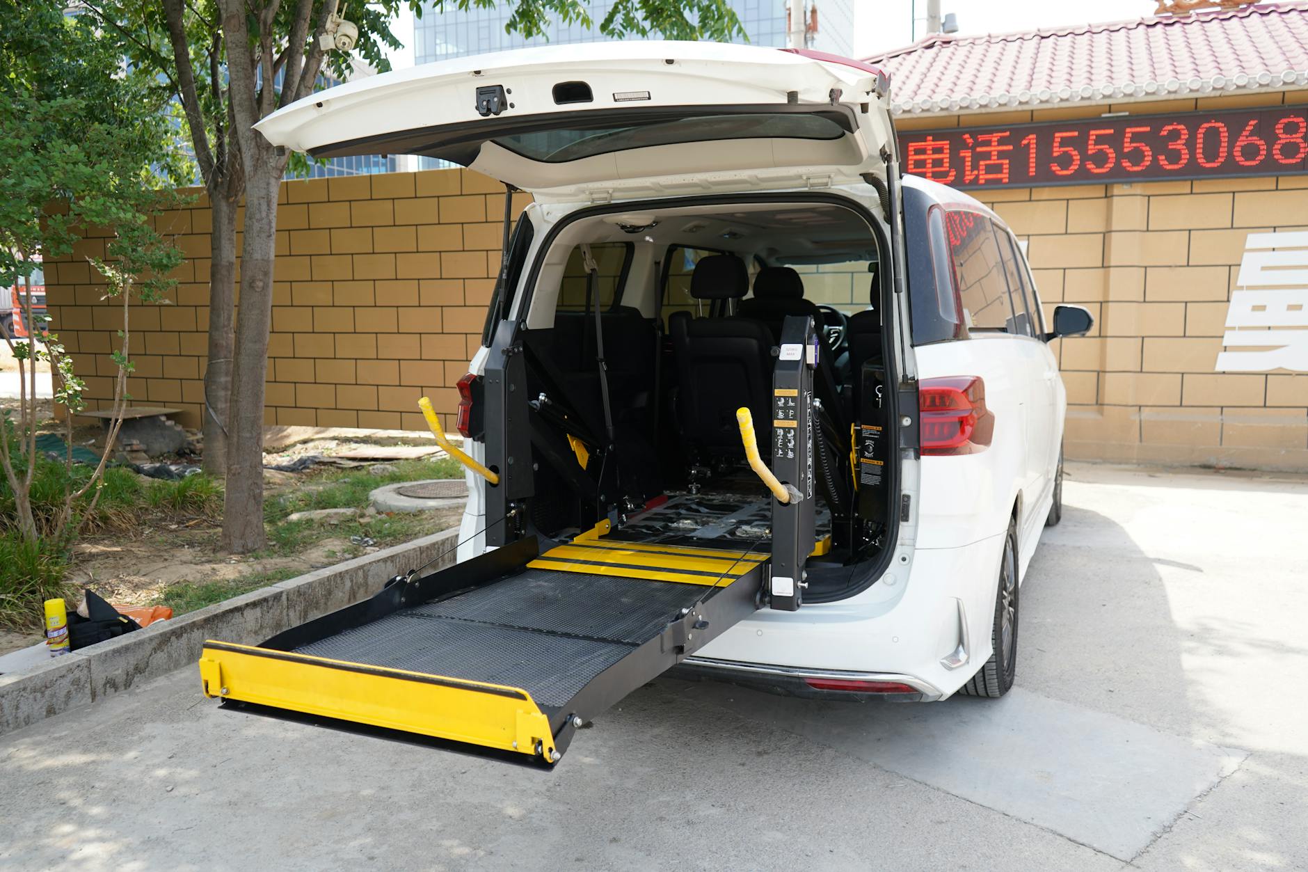 Minivan z zamontowaną windą dla wózka inwalidzkiego na parkingu