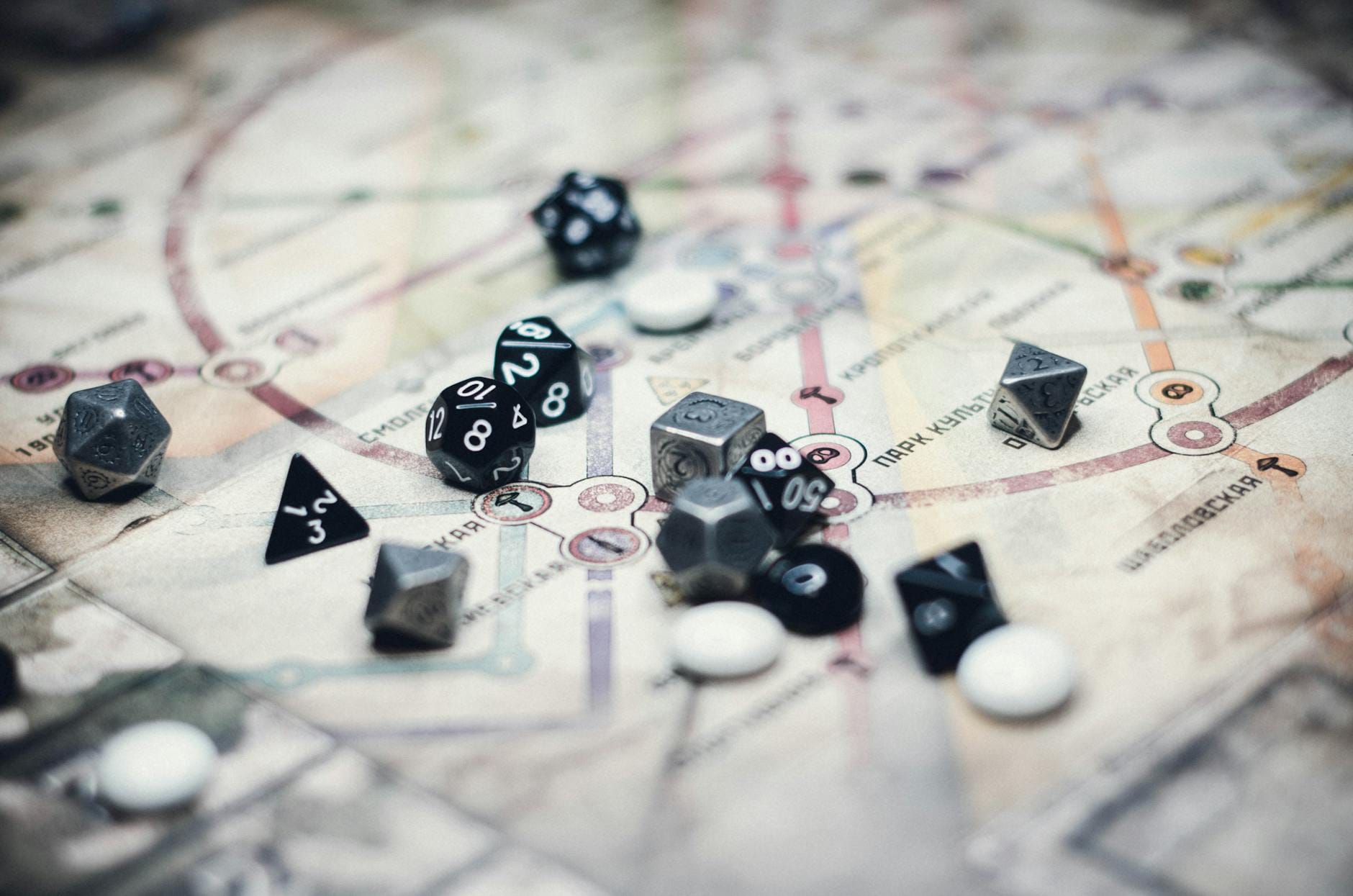 Wielokątne kości do gry rozrzucone na szczegółowej mapie RPG