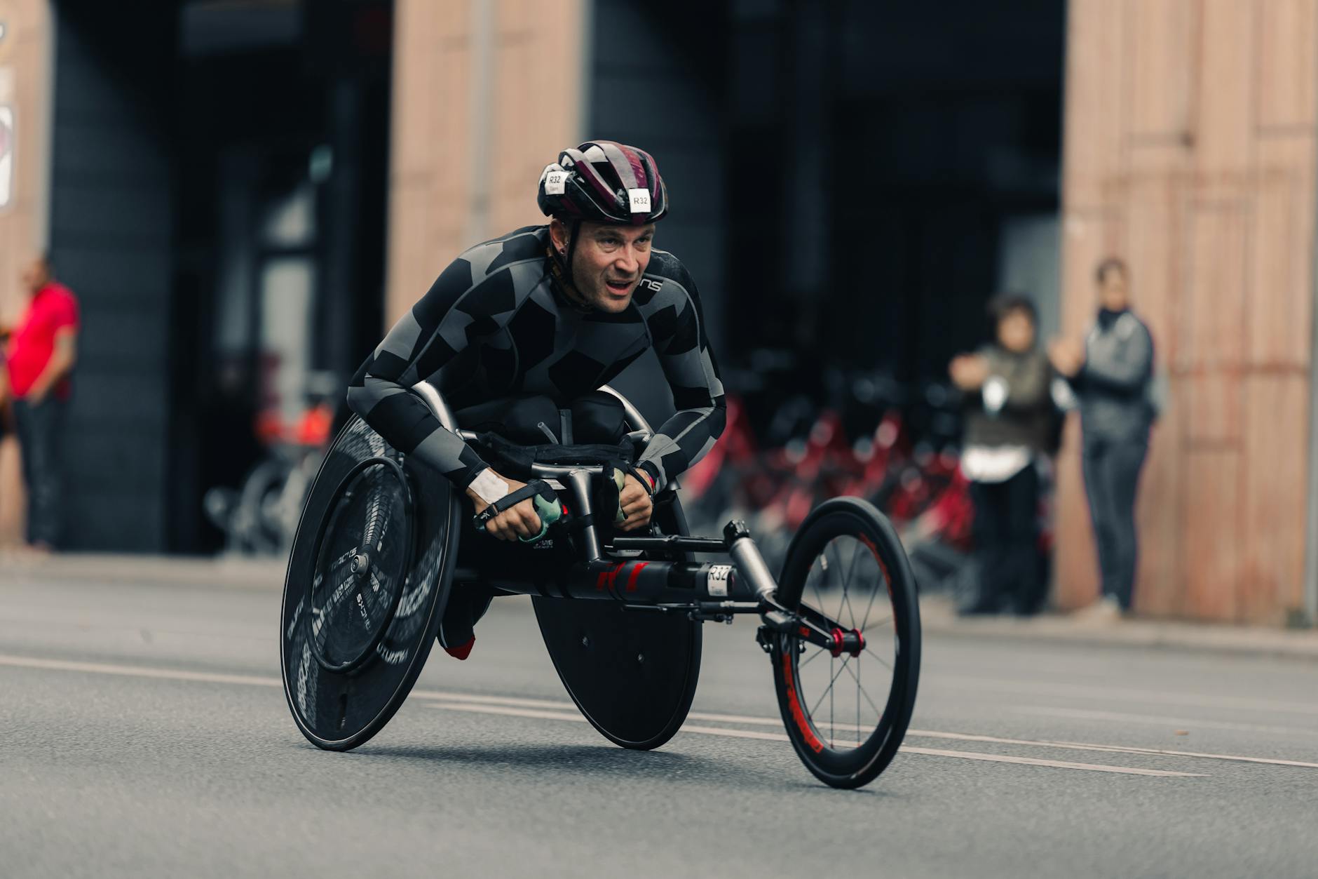 Zawodnik na wózku aktywnym jedzie ulicą podczas maratonu w mieście