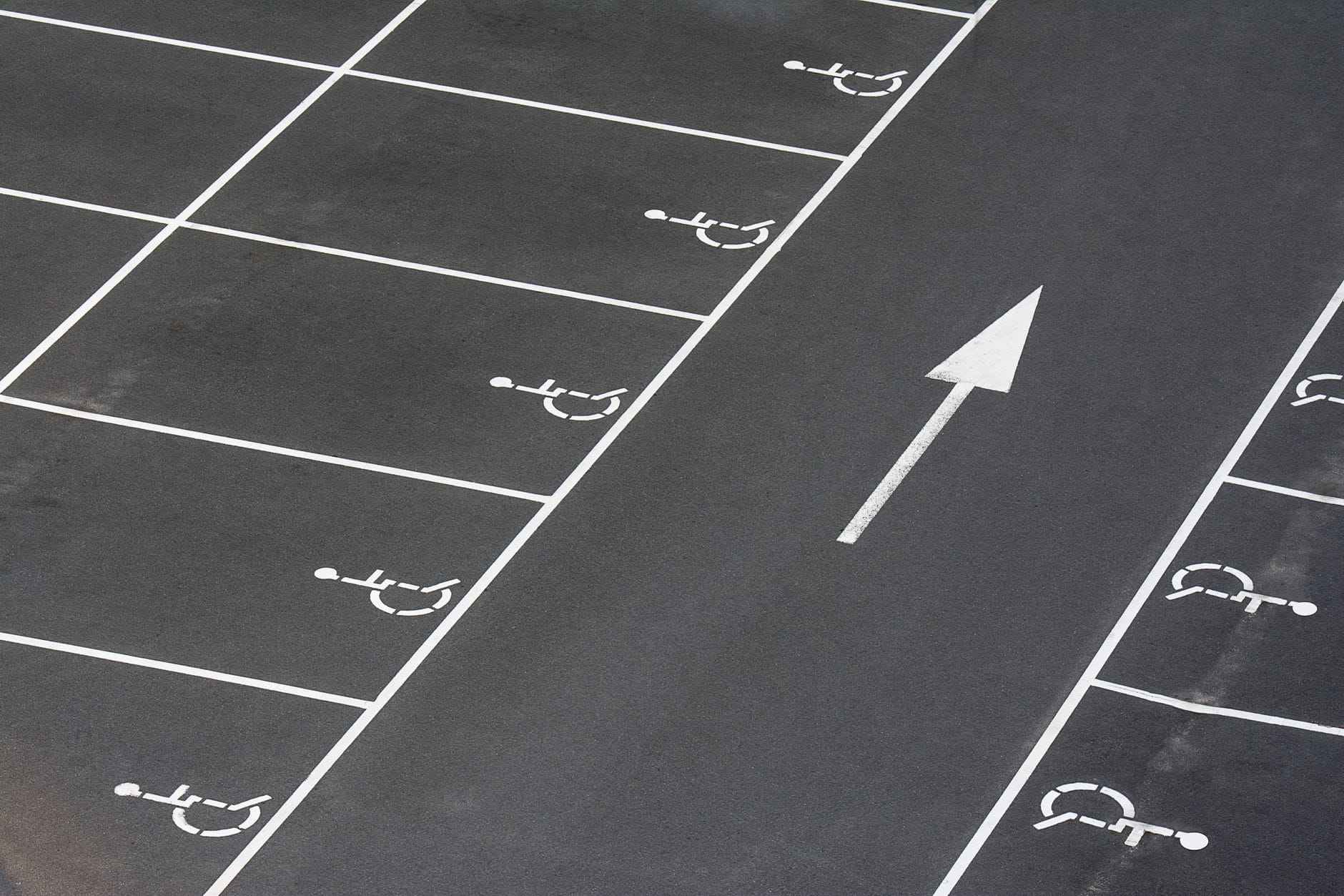Oznakowane miejsca parkingowe dla osób z niepełnosprawnościami i strzałka