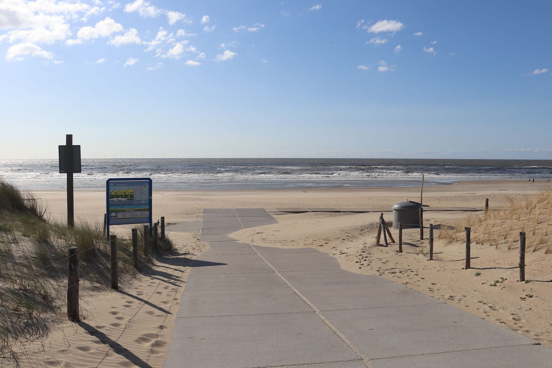 Drewniana kładka przez wydmy prowadząca na piaszczystą plażę nad Bałtykiem