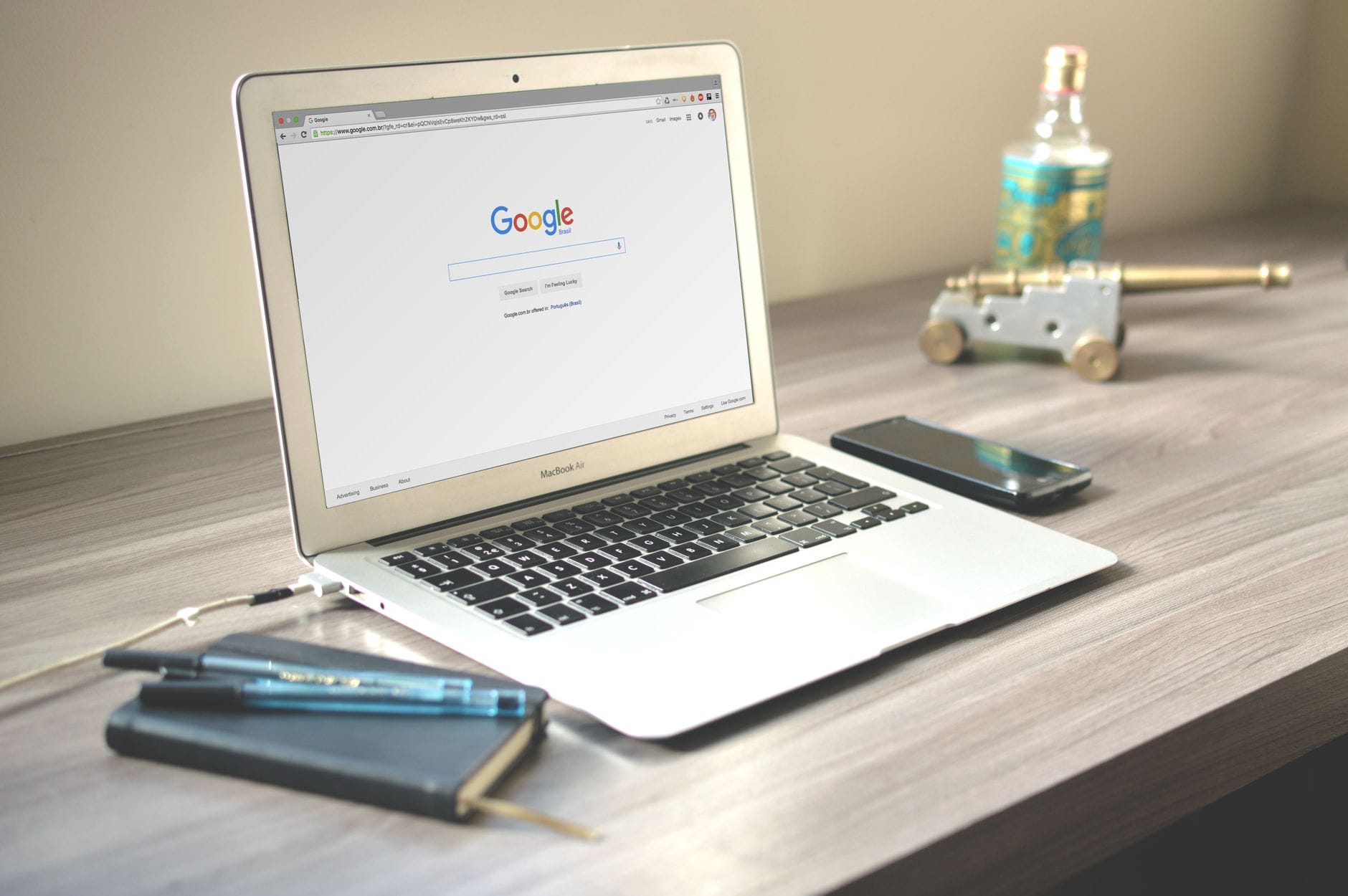 Biurko z laptopem z wyszukiwarką Google, telefonem i notesem