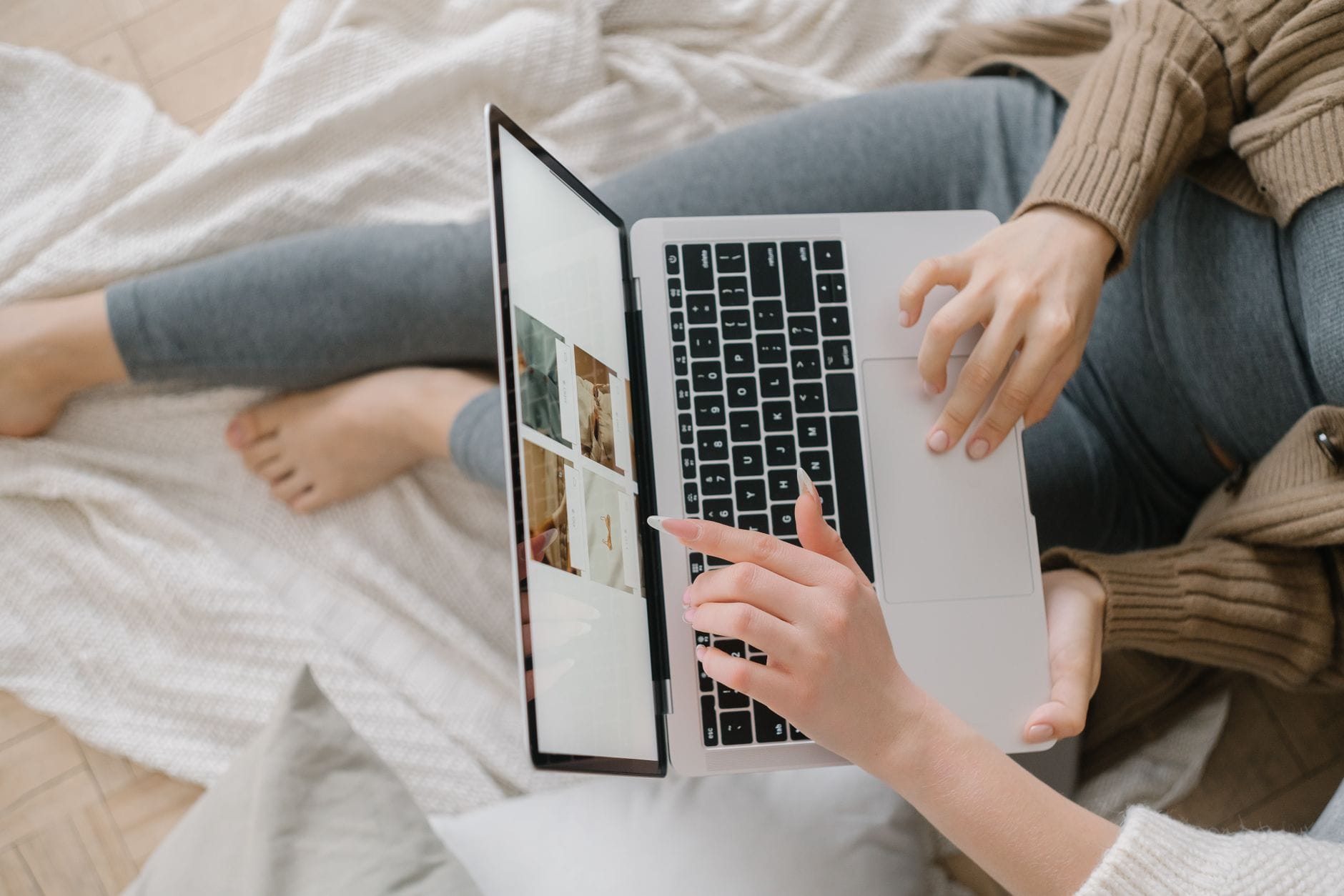 Kobieta na łóżku sprawdza dostępność apartamentu na laptopie